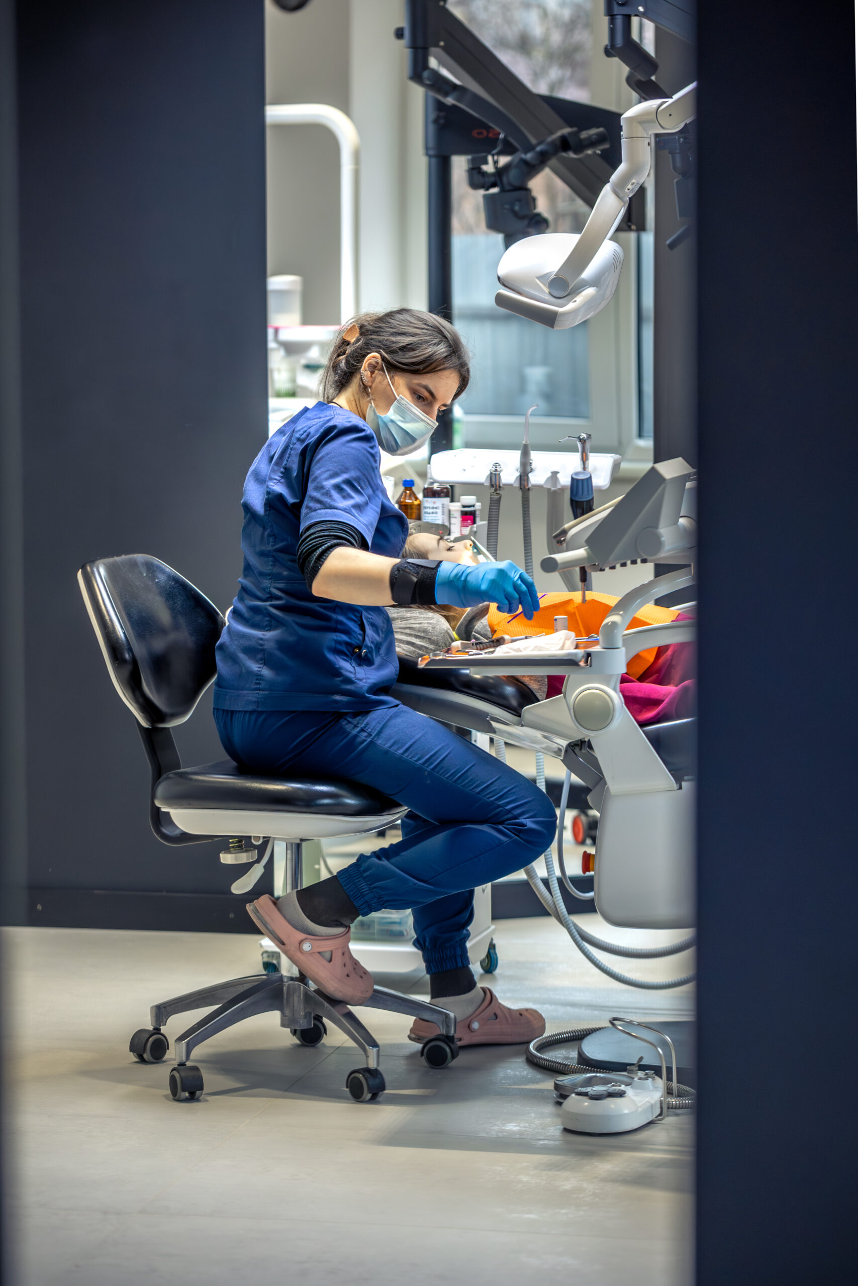 Young female dentist in dental office. Dentist at work. Dental treatment concept. High quality photo. Young woman dentist treating kid tooth, little girl sitting in dentists office. SSUCv3H4sIAAAAAAAAA41Py26DMBD8lz2DZIrTAr8S9eDHlqwCOLKXRhHyv2dNiHqtTzM73pnZDcjDANpg33RW1d4qrJsGf2rbK1O7L62xazv36TxU4A0jDE3bdh8nrbQ66aZX8iqwJpGDYQOapjVxNExhgUGUiIvHuEP0xCGSmYTlChIbXhMmWRPmxHsUdedvv/NW5lJQwtNqC8jVP2ffFZgRF/co/rkUmdDscWeRrnfGOB/ZgS+lYoG3SI6W8egkp4T5hZfAZXdP4OCu5I/l1xkXkmksWbDepmA8+kNe7UzMbxrxl/D+9zvn/AR/D/1ZhAEAAA==